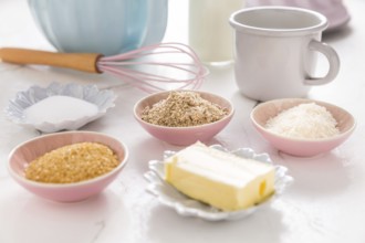 Baking ingredients and kitchen utensils on white wooden background
