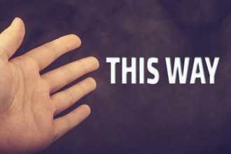 Hand making welcome gesture with THIS WAY wording