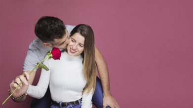 Guy kissing presenting fresh rose attractive cheerful lady