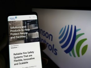 Stuttgart, Germany, 03-12-2022: Person holding cellphone with webpage of company Johnson Controls