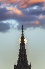 Full moon behind the minster of Ulm at sunset