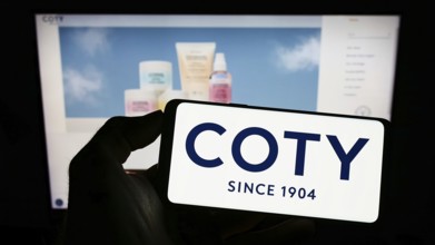 Stuttgart, Germany, 10-03-2022: Person holding cellphone with logo of US beauty company Coty Inc.
