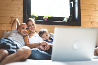 Young family with a girl, spending time at home on the weekends. Loving family resting on the