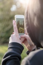 Teenage boy taking photographs with a smart phone