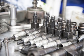 The old diesel injectors lie on the table in the fuel shop. The concept of repair of fuel diesel