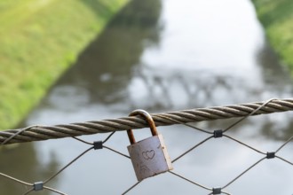 Love lock on railing over sewer