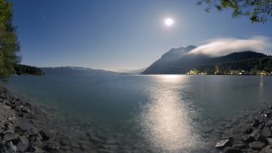 Mountain lake Walchensee with village Urfeld and Herzogstand in Bavaria, Germany at night with