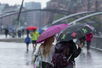 Symbolic picture weather, heavy rain in summer, thunderstorm, thunderstorm, tourists with umbrellas