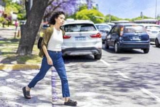 Casual woman looking for a taxi on a busy street