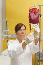 A nurse in hospital with blood bottle. Infusion of donor blood, A nurse in hospital with blood