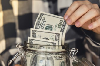 Dollar banknote saving money in glass jar. Unrecognizable woman moderate consumption and economy