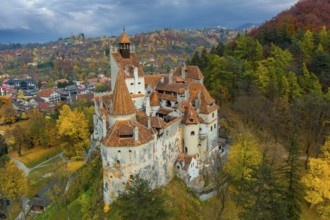 Aerial view of Bran castle in Transylvania region, Romania. Autumn season and dark clouds