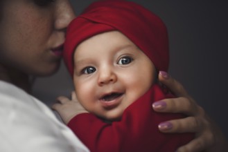 Loving Mother Cuddling Newborn Baby daughter Over Shoulder