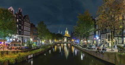 A picture of the Red Light District and the Basilica of Saint Nicholas in the distance, at night,