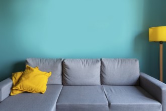 Luxury living room template with modern interior design, turquoise empty wall, gray sofa, yellow
