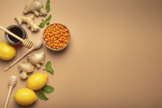 Lemons, mint, ginger, sea buckthorn berries, honey in glass jar, honey wooden dippers top view.