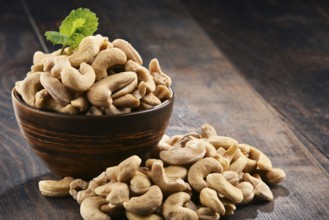Bowl with cashew nuts on wooden table. Delicacies