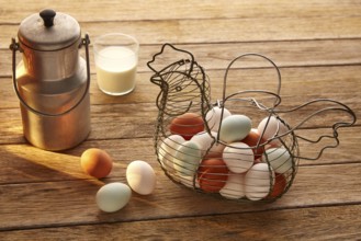 Eggs and milk in a vintage hen shape basket on wood with blue easter white and brown