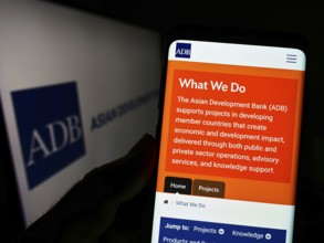 Stuttgart, Germany, 08-28-2022: Person holding cellphone with webpage of organization Asian