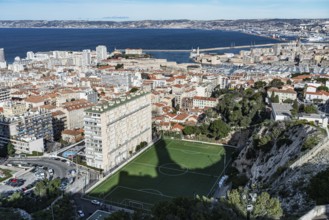 View of football pitch, houses, old harbour and Mediterranean Sea, Marseille, France, Europe