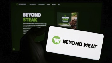 Stuttgart, Germany, 09-11-2023: Person holding mobile phone with logo of American meat substitute
