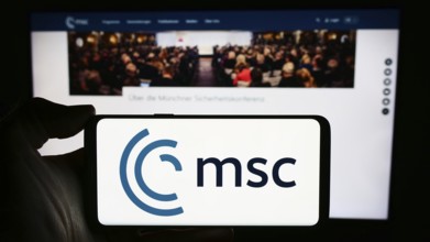 Stuttgart, Germany, 03-06-2024: Person holding cellphone with logo of annual event Munich Security