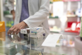 Medications stacked on a pharmacy counter, ready to be sold. Represents a typical scene in the
