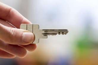 Holding a house key in the hand: New home and property