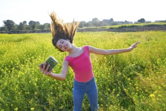 Teen girl selfie video photo in spring meadow moving hair
