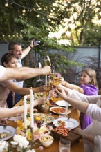 HAppy friends saying cheers and showing their champagne glasses full of sparkling wine to each