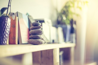 Feng Shui: Stone cairn in the foreground, blurry living room in the background. Balance and