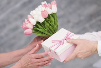 Man s hand giving birthday gift tulip flowers bouquet his wife
