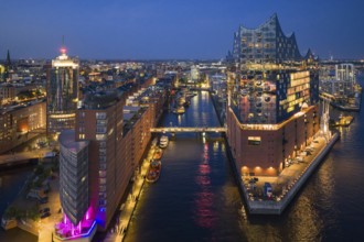 Aerial view of the Elbphilharmonie at blue hour with illuminated windows and view over the