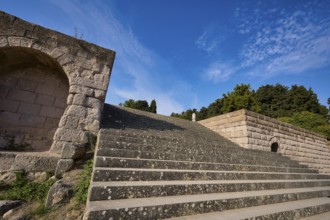 Stone staircase with ancient structures, surrounded by trees and clouds, open staircase to the