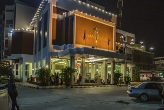 Customers around the entrance of a the Mangcome Hotel at night in Chiang Rai, Thailand, Asia