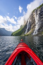 Kayak trip on the Geirangerfjord at the waterfall The Seven Sisters, tip of a red kayak in the