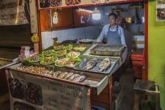 Thai street vendor offers fresh cooked seafood at the night market in downtown Chiang Rai,