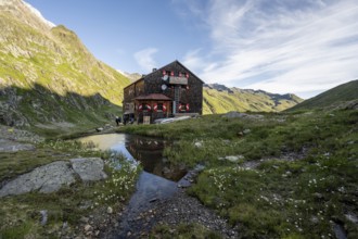 Mountain hut Elberfelderhütte with small lake and cotton grass, in the morning light, in the upper