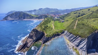 Aerial perspective captures the stunning beauty of zumaia's flysch cliffs meeting the vibrant blue