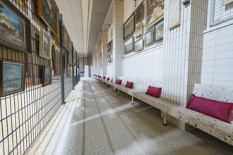 Long corridor with paintings on the walls and upholstered benches, historical art exhibition in the