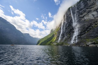Geirangerfjord at the waterfall The Seven Sisters, tip of a red kayak in the fjord, atmospheric