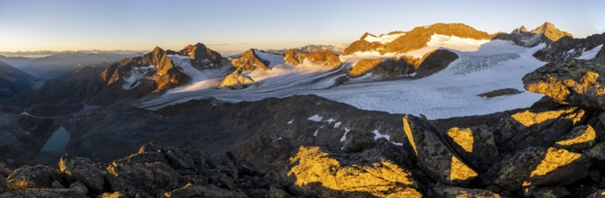 Picturesque high mountain landscape at sunrise with alpenglow, blue glacial lakes, glaciers and
