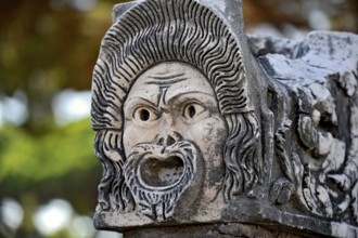 Ancient stone sculpture, stone carving of a mask, Roman theatre, ancient port city of Rome,
