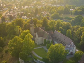 Aerial view of a village with a church complex and dense tree population, event and wedding