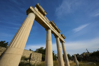 Ancient temple columns under a clear blue sky in a historical landscape, Archaeological site, Xysto