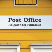 Yellow lobster shack, sign with inscription post office, Helgoland philately, facade detail, Museum