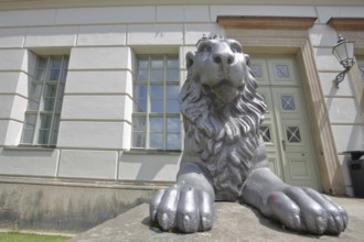 Head of lion figure with paws and entrance to historic lion building, front door, palace, modern