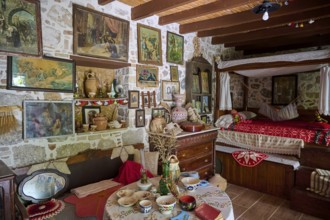 Niotis Restaurant, Rustic living room with antique furnishings, painted walls and paintings and a