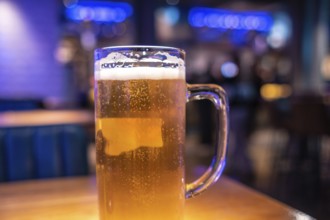 Cold beer waiting on the table in a lively london pub, inviting friends to enjoy a refreshing drink