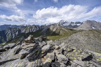 Cairn on the summit of Kastenegg, view of picturesque mountain landscape with snow-covered summit